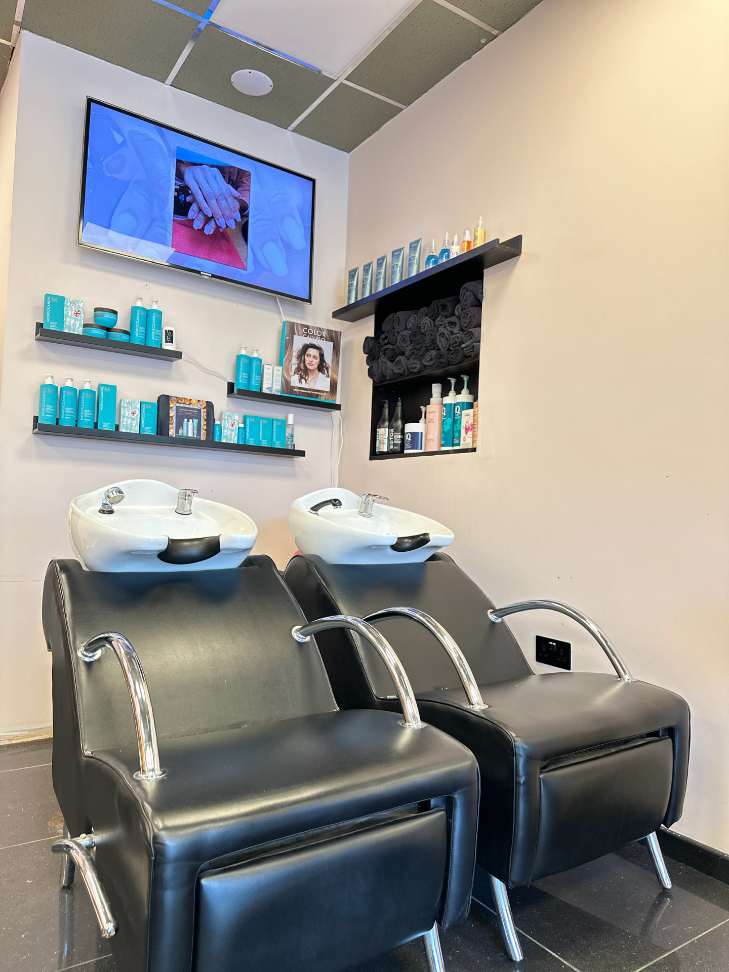 Backwash basins and haircare shelves in the hair washing area.