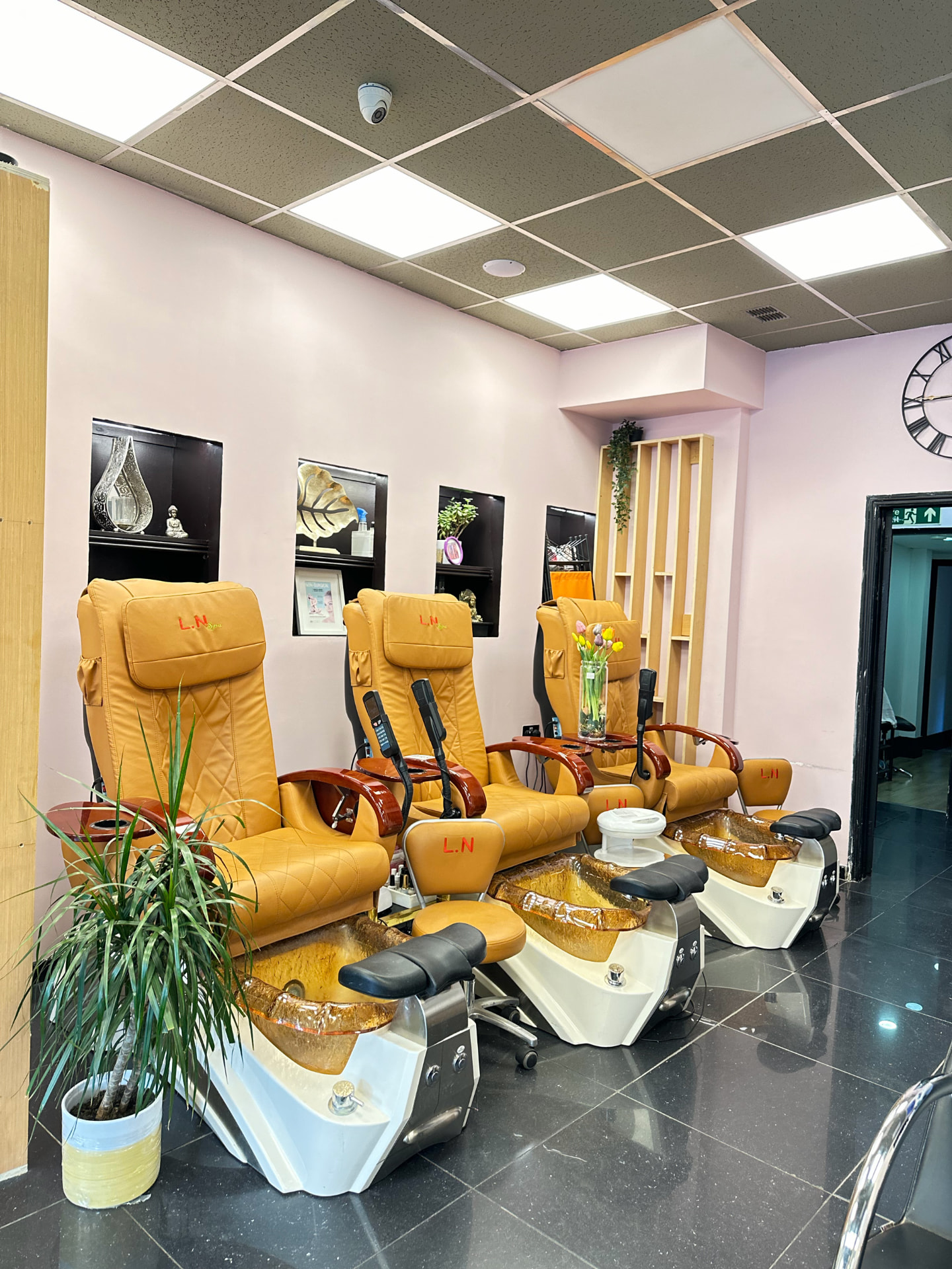 Pedicure spa chairs in the blush-pink pedicure room.