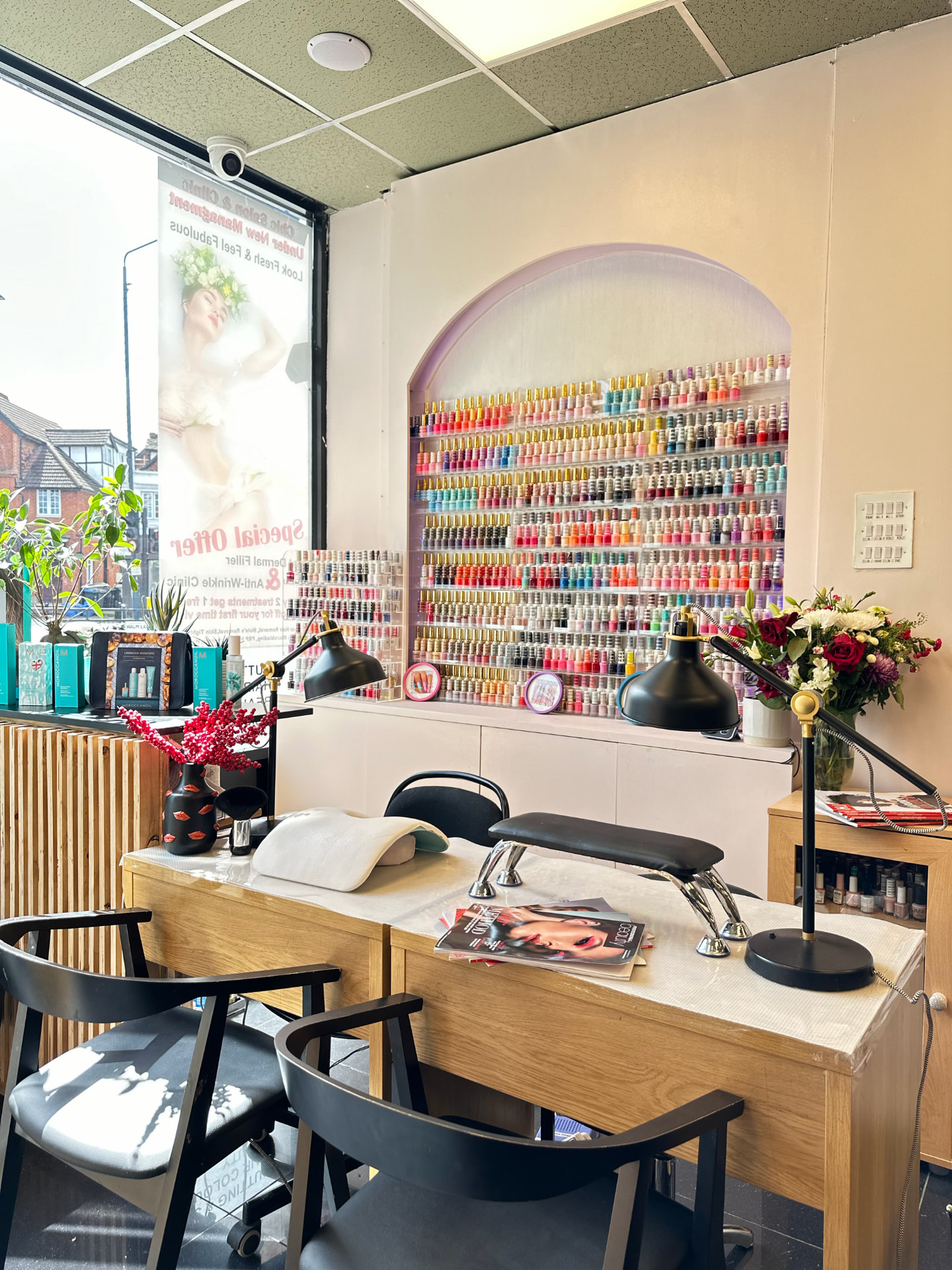 Manicure table in front of the arched nail polish colour wall.